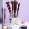 A collection of thirteen professional makeup brushes with various shades of brown and gray bristles displayed in a clear box.