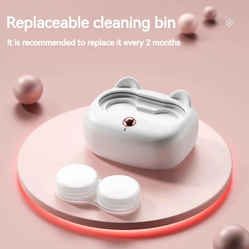 A white cleaning bin for contact lenses is shown on a pink surface with cleaning pads.