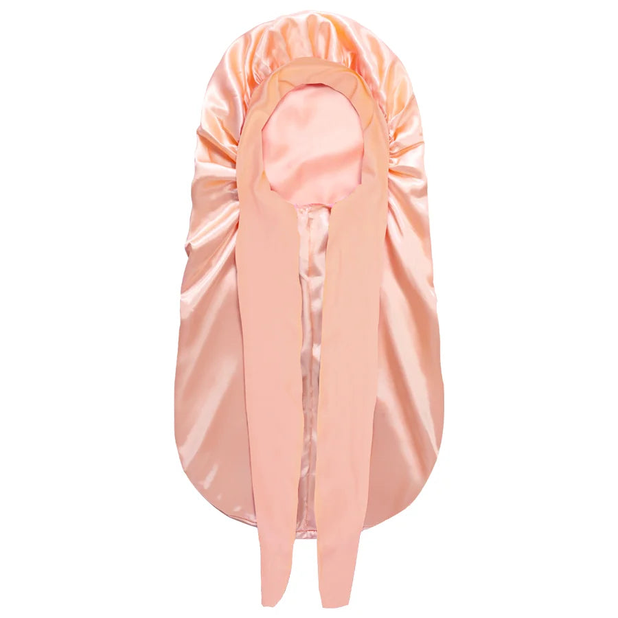 A peach-colored satin silk hair bonnet cap shown flat.