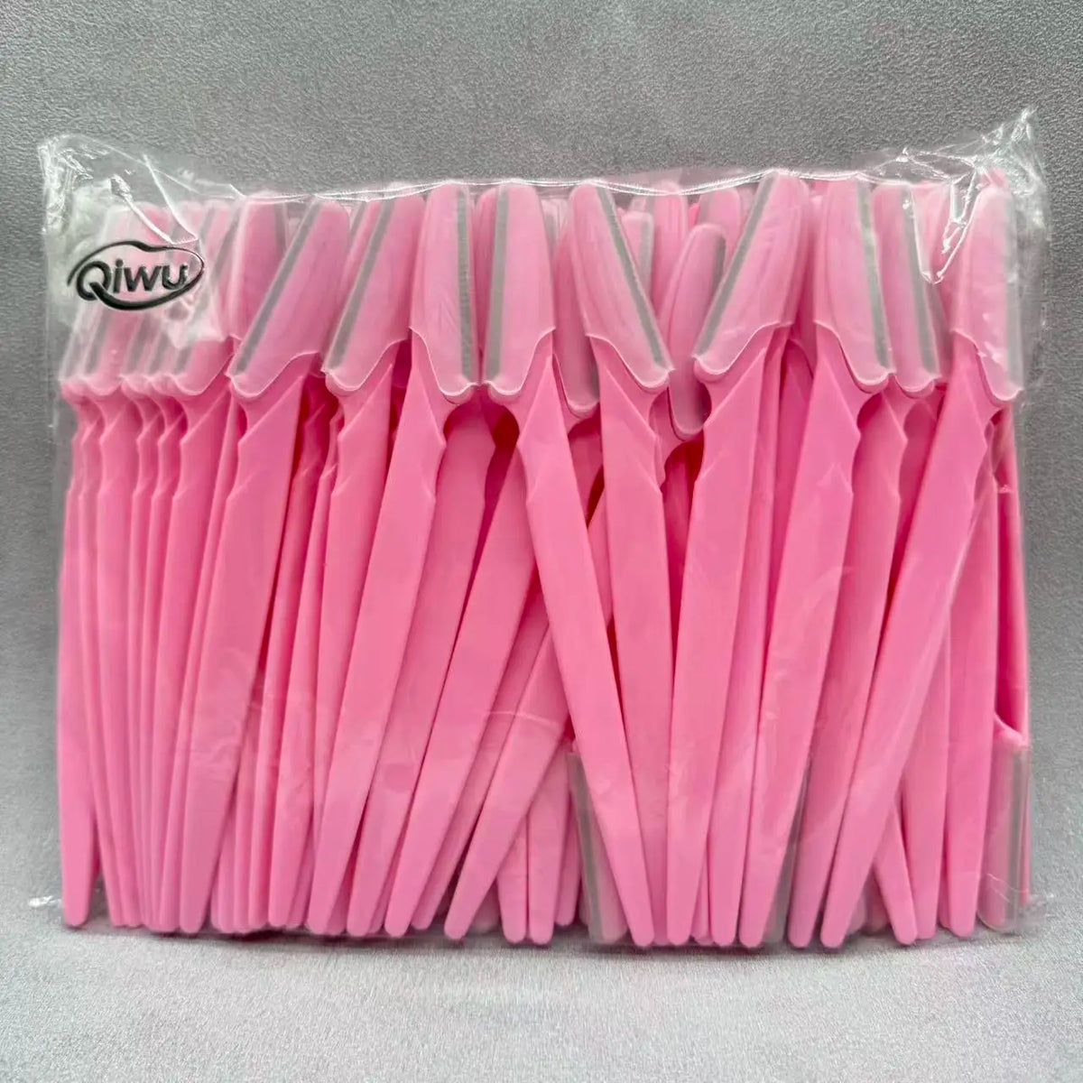 Un lot de bandes de tondeuse à sourcils roses emballées dans un sac plastique transparent.