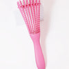 A pink adjustable detangling hair brush with numerous thin bristles is shown against a white background.