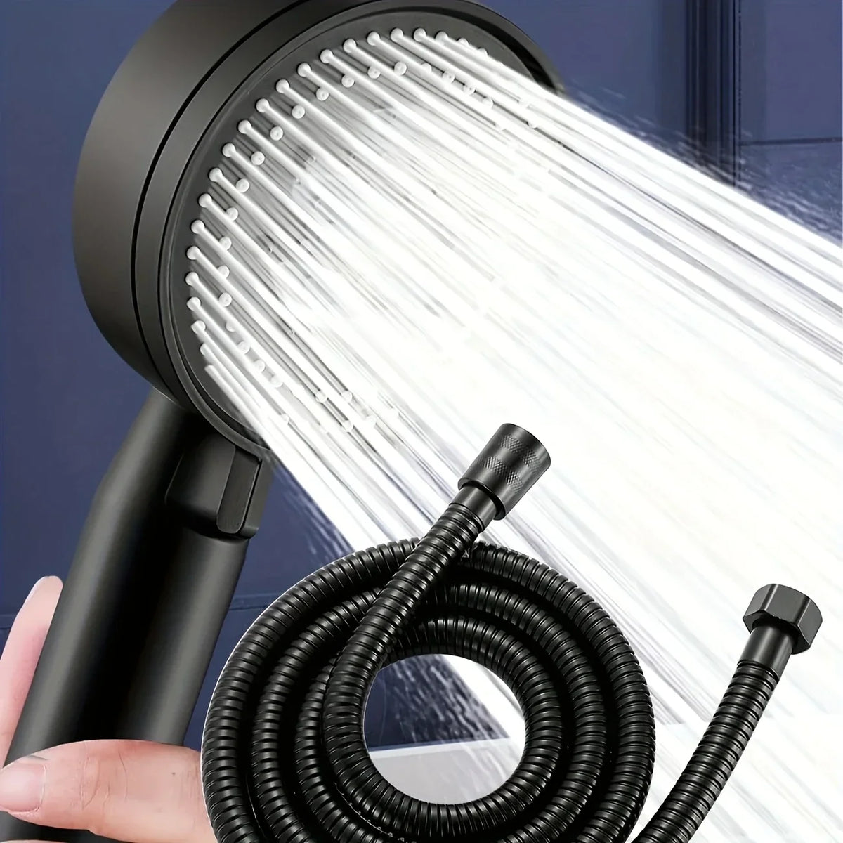 A black high-pressure handheld shower head and coiled hose are shown spraying a strong stream of water.