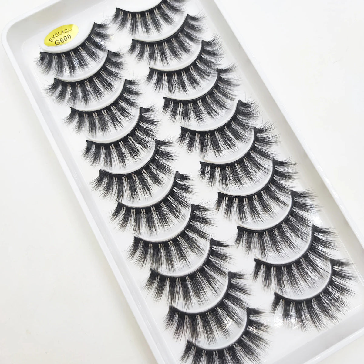 A tray of natural 3D mink false eyelashes with a yellow label labeled GG00.