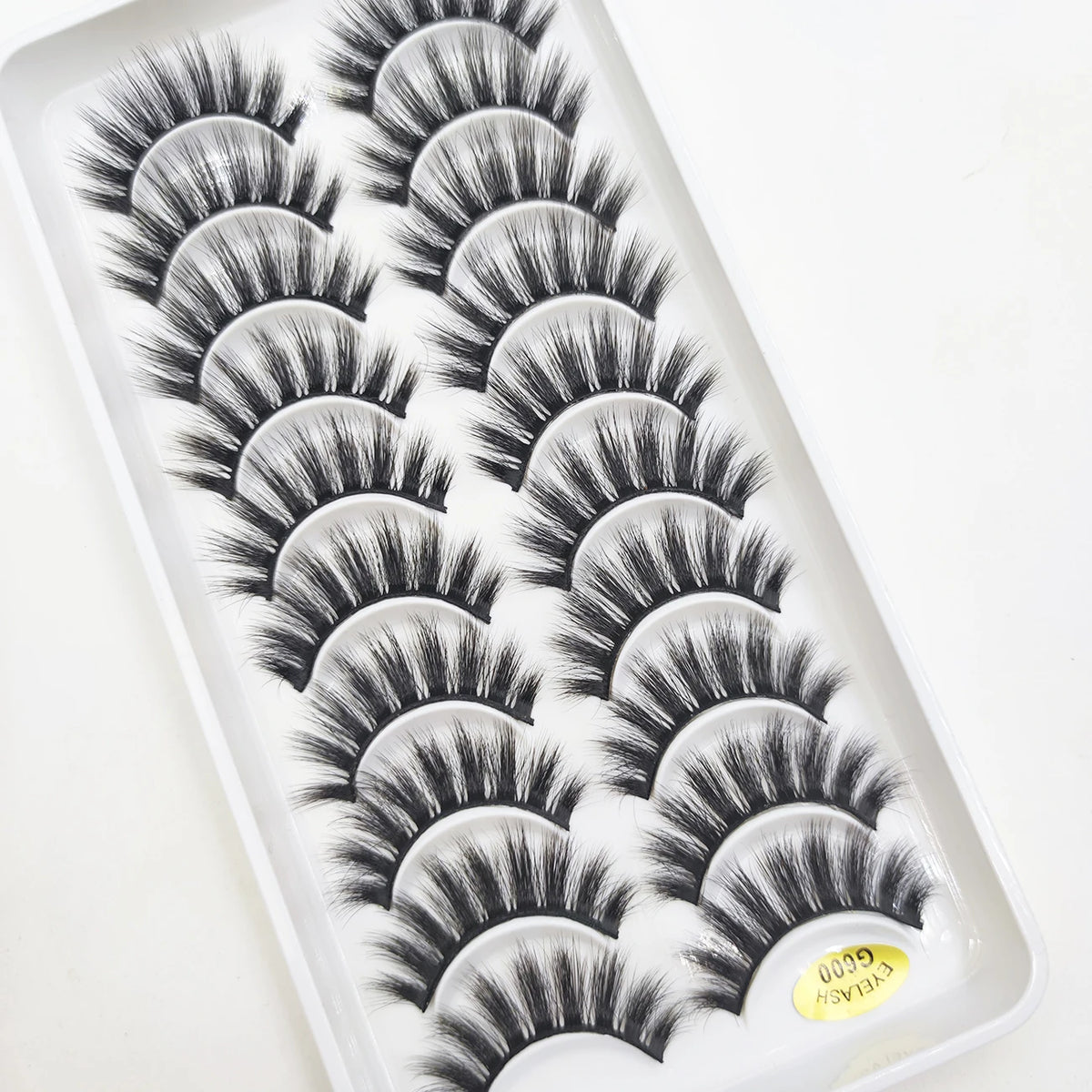 A tray of natural 3D mink false eyelashes displayed in a white plastic container.