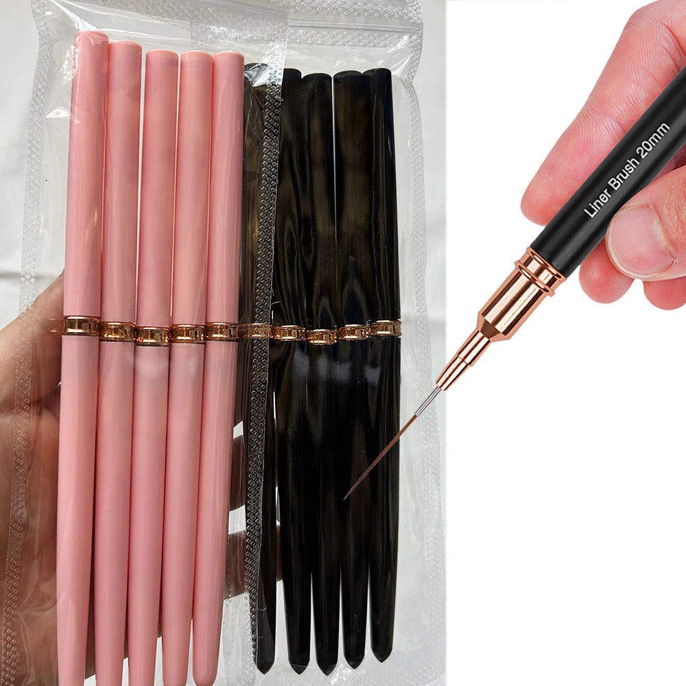 Un set de pinceaux de liner pour ongles professionnels noirs et roses, tenu par une main.