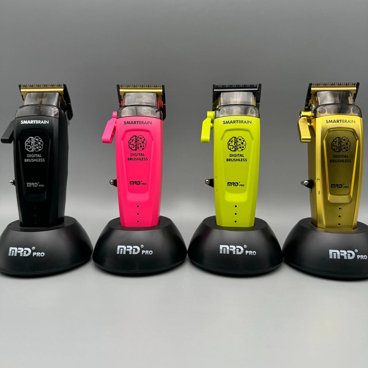 Four electric hair clippers in black, pink, lime green, and gold displayed side by side.