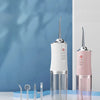 A pink and white portable USB rechargeable water flosser for dental cleaning displayed on a glass stand.