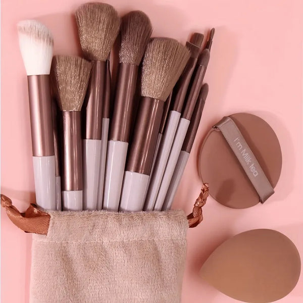 A collection of 15 makeup brushes in various shades and sizes displayed in a beige pouch.
