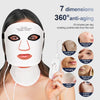 A woman is applying a white LED facial mask to her face, demonstrating its anti-aging benefits.