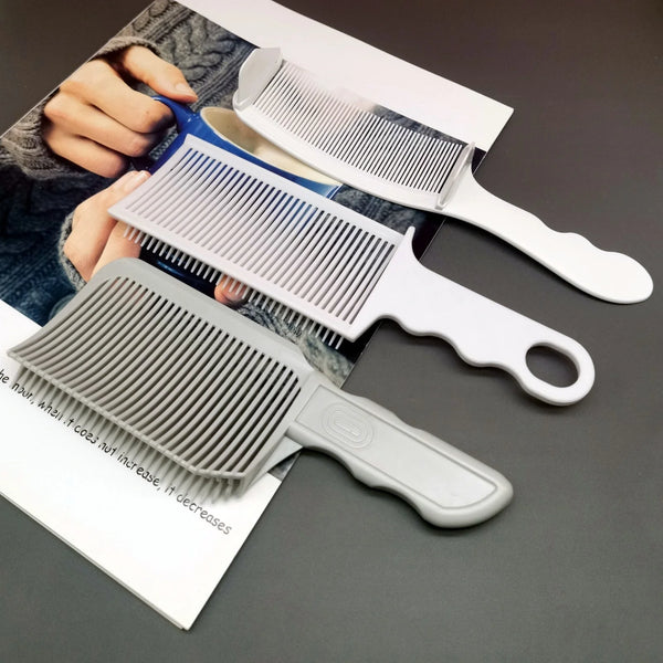 A set of professional flat top hair cutting combs in white and gray are displayed on a dark surface.
