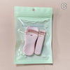 A clear plastic pouch containing a pink cartoon mini eyelash curler and tweezers for beauty makeup tools.