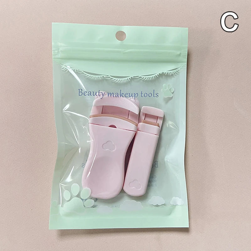A clear plastic pouch containing a pink cartoon mini eyelash curler and tweezers for beauty makeup tools.