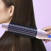 Primer plano de cabello oscuro siendo peinado con un cepillo térmico profesional para suavizar y cuidar.