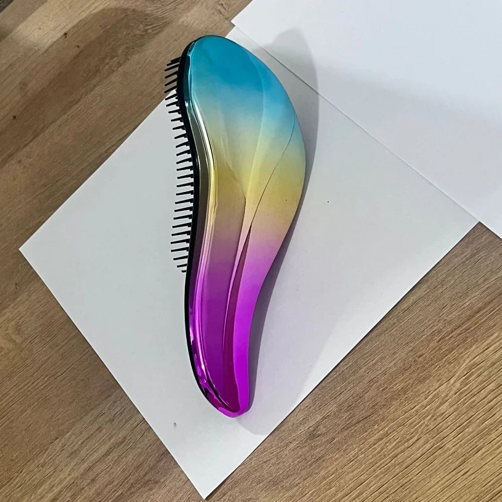 A glossy, iridescent purple and blue detangling hair brush lying on a white surface.