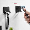 Une main installe un porte-savon multi-fonctionnel sur un mur blanc, montrant son utilisation pour organiser la tolie