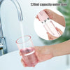A hand is using a pink 220ml capacity water tank oral irrigator to clean a glass.