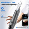 Primer plano de un dispositivo ultrasónico de limpieza dental plateado sostenido por una mano, con un smartphone mostrando mo