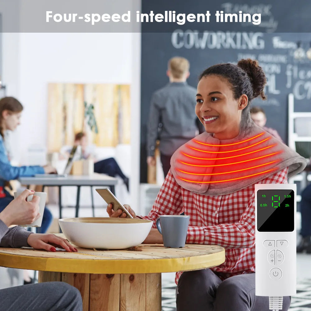 A woman is using an electric heated neck and shoulder massager while sitting at a table in a co-working space.