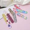 A collection of colorful double-sided nail files and buffing blocks arranged on a pink surface.