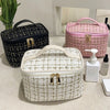 A collection of three knitted canvas makeup pouches in black, pink, and cream resting on a light surface.