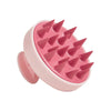 A pink silicone scalp massage and body brush with pointed bristles.