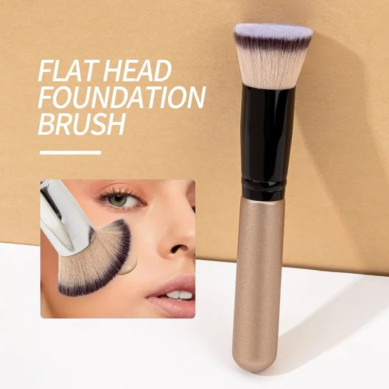 A flat head foundation brush with a brown handle and light pink bristles shown next to its packaging.