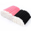 A collection of disposable lip wands in pink, white, and black arranged diagonally.
