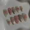 A collection of 24 pink heart pearl press-on fake nails displayed on a white surface.