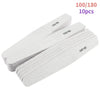 A collection of 10 pieces of white professional grit nail files for manicure and shaping.