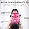 A woman is wearing a pink multi-wavelength LED face therapy mask for skincare.