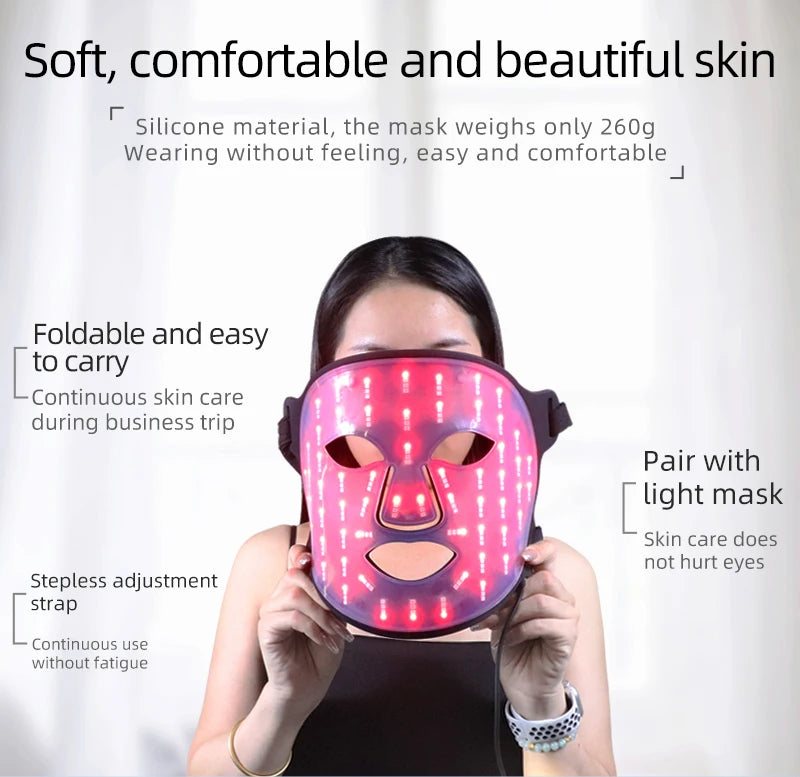 A woman is wearing a pink multi-wavelength LED face therapy mask for skincare.