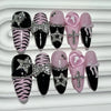 A set of glitter diamond press on nails featuring black, pink, and zebra print designs.