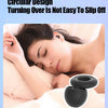 A close-up of a black silicone ear plug resting on a person's ear, demonstrating its circular design.