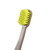A bright yellow extra large toothbrush with numerous bristles is shown on a wooden handle.