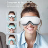 A woman is wearing a white heated eye massager device while smiling, demonstrating its use for relaxation.