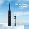 A black electric teeth cleaner device standing next to a white toothbrush on a marble surface.