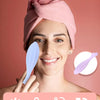 A woman is using a pink silicone face massager roller for facial massage and blood circulation.