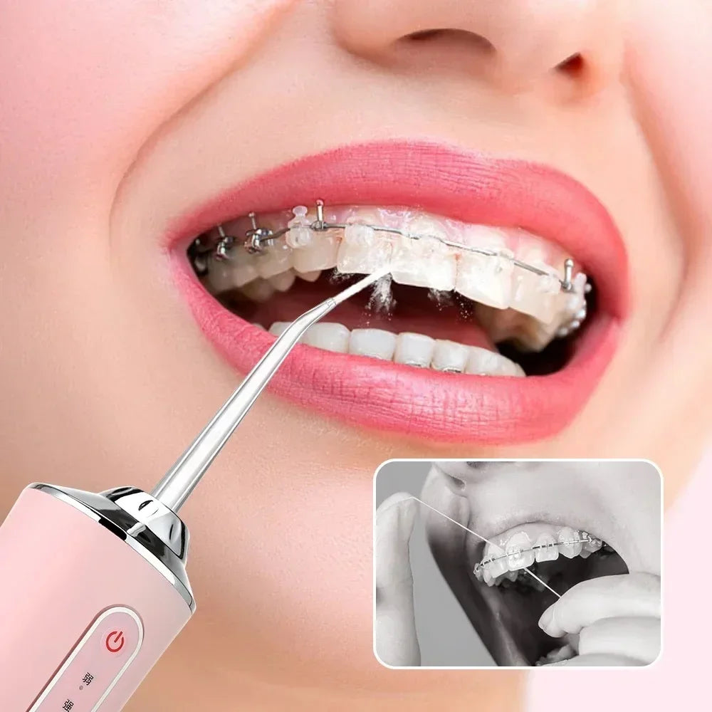 A pink dental water flosser is shown being used on a person's mouth, demonstrating its use for oral hygiene.