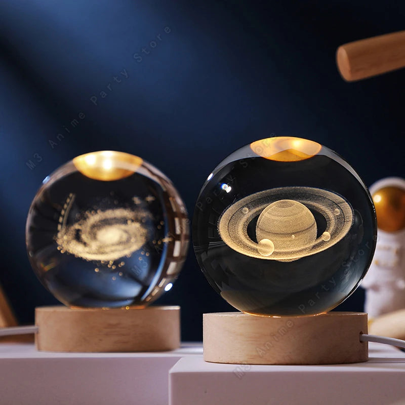 A glass crystal ball night light with a swirling galaxy design resting on a wooden base.