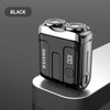 A black mini electric smart shaver resting on a light gray surface.