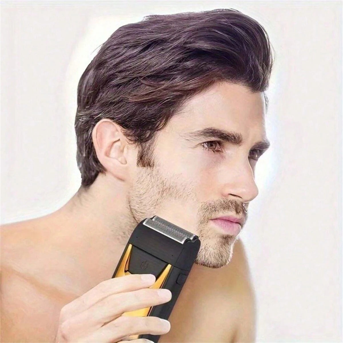 A man is using a black electric double-blade hair shaver on his face.
