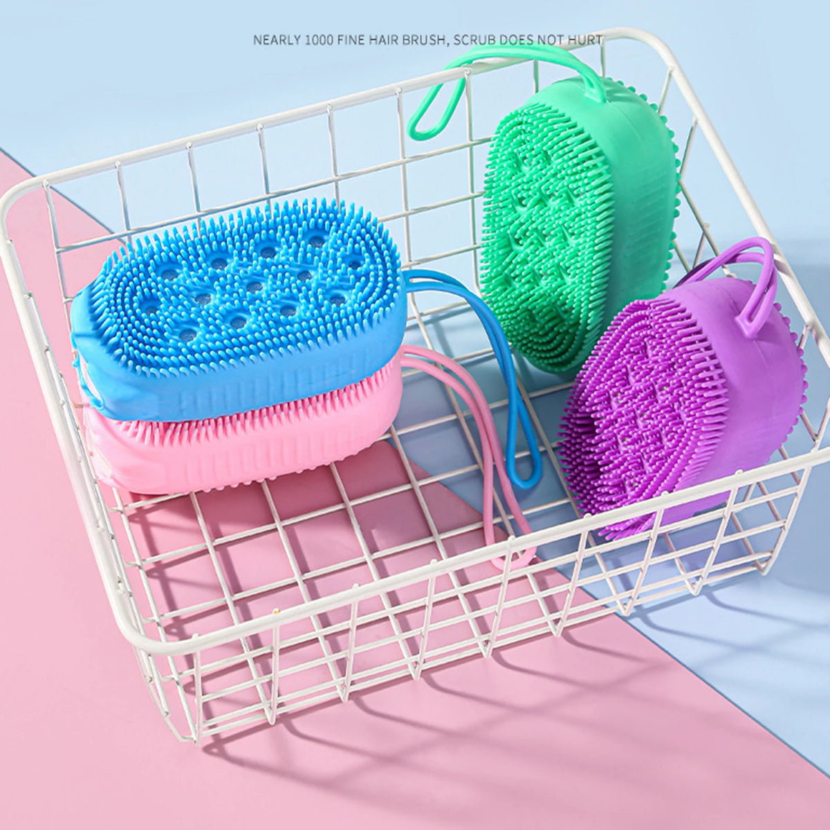 A white wire basket holds three silicone body brushes in blue, pink, and green.