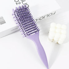 A purple professional curly hair styling comb with a plastic handle is shown next to a white product box.