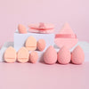 A set of 12 pink makeup sponges and applicators arranged on a white surface.