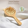 A wooden bamboo hair brush with numerous bristles is shown on a white surface.