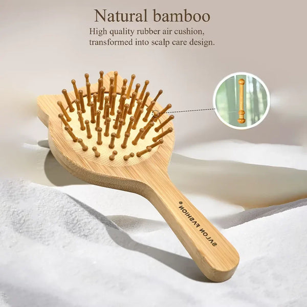 A wooden bamboo hair brush with numerous bristles is shown on a white surface.