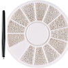 A circular plate of gold mixed stainless steel bead nail art decorations is shown with a black tool.