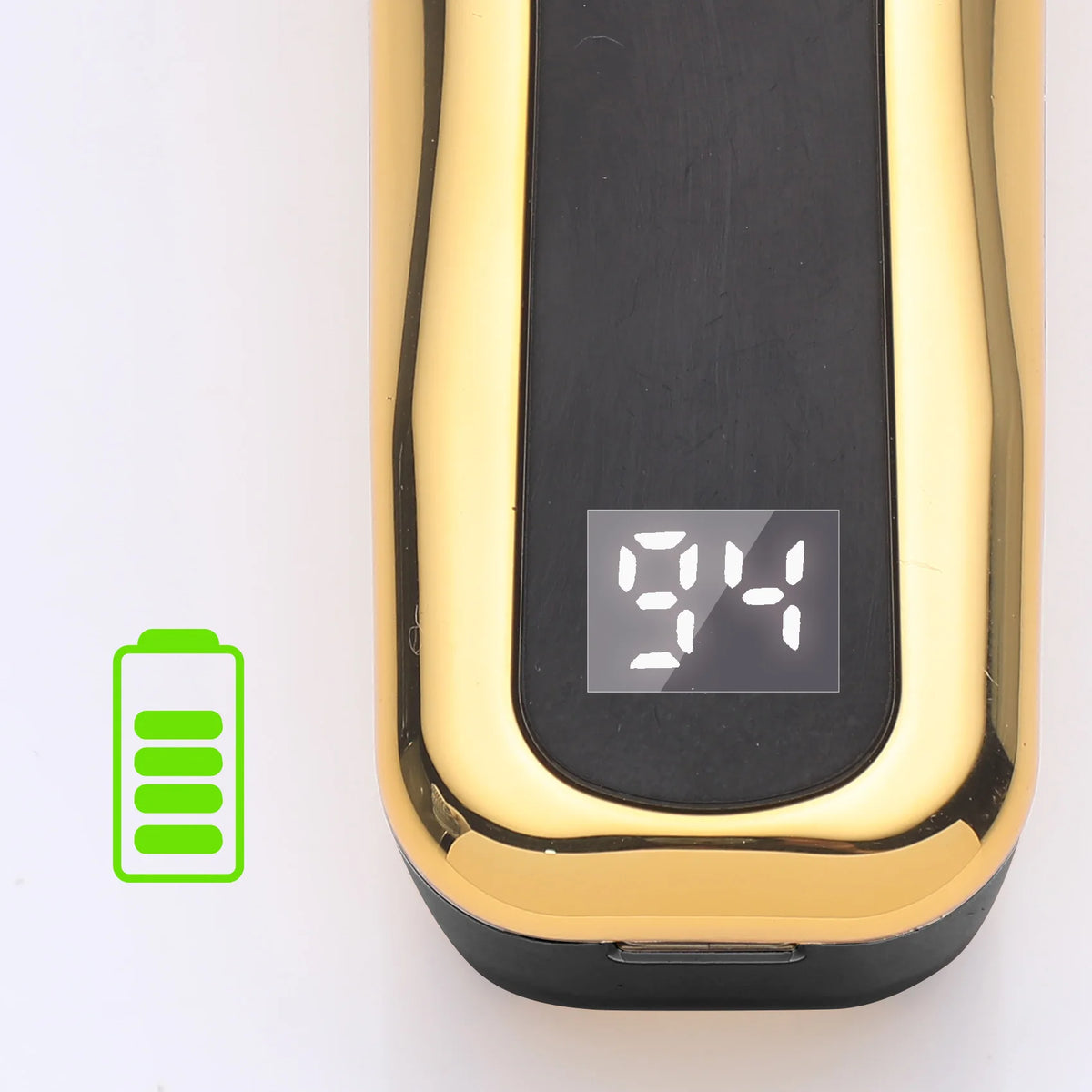 A close-up view of a professional LCD hair clipper set with a black body and gold accents, showing a battery indicator.
