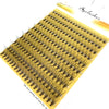 A fan-shaped cluster of mink lashes is displayed on a yellow plastic strip.