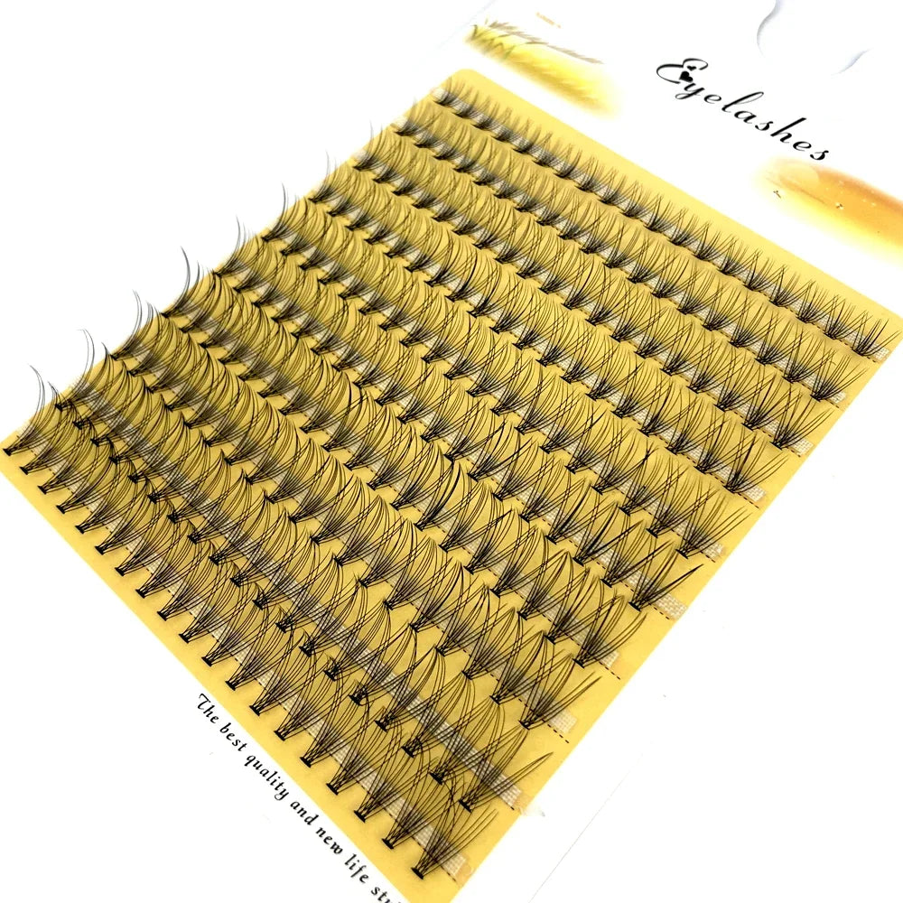 A fan-shaped cluster of mink lashes is displayed on a yellow plastic strip.